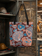 Bolsa tote bag colección “Mecanismos Afectivos” con patrón de corazones mecánicos isométricos, colgada de casillero en fábrica.