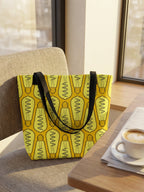 Maqueta de bolsa tote bag en tonos amarillos con patrón de bombillas, en cafetería; diseño de GyGinfographics.