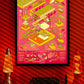 Digital mockup featuring the "Atari 2600 – Exploded Diagram" poster displayed in a styled environment. The original poster was illustrated by Francisco GyG. The background was generated using AI and is marked with diagonal bars to distinguish it from the original design.