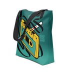 Vista general de tote bag verde y amarilla con cassette lado B y pluma Bic rebobinando cinta; efecto 3D con cinta alineada a las asas.