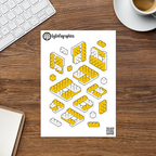 Planilla de stickers (calcomanías) de bloques y ensambles imposibles tipo LEGO en proyección isométrica, sobre escritorio.