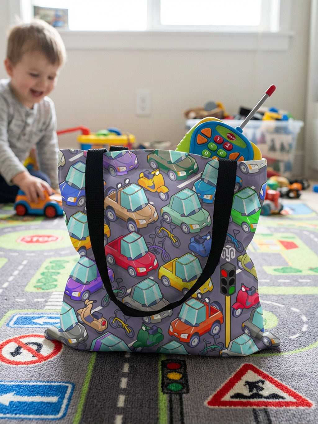 Sac fourre-tout avec anses noires et imprimé enfantin représentant un parking isométrique avec des voitures, des motos et des vélos multicolores, vue 3/4.