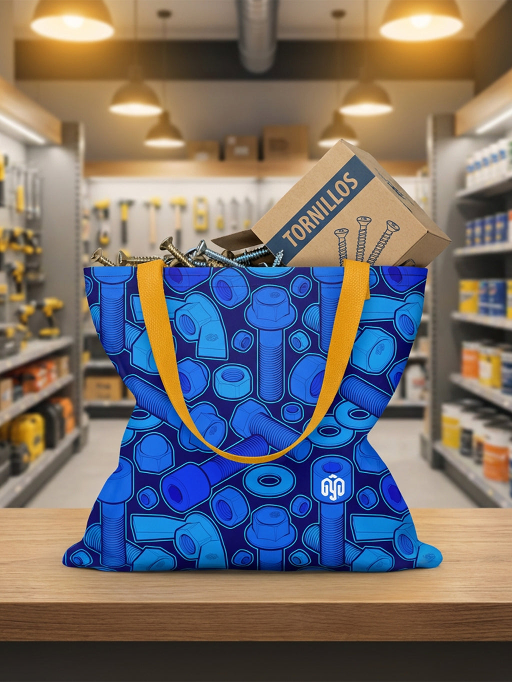 Tote bag con estampado de tornillería en tonos azules sobre el mostrador de una ferretería.